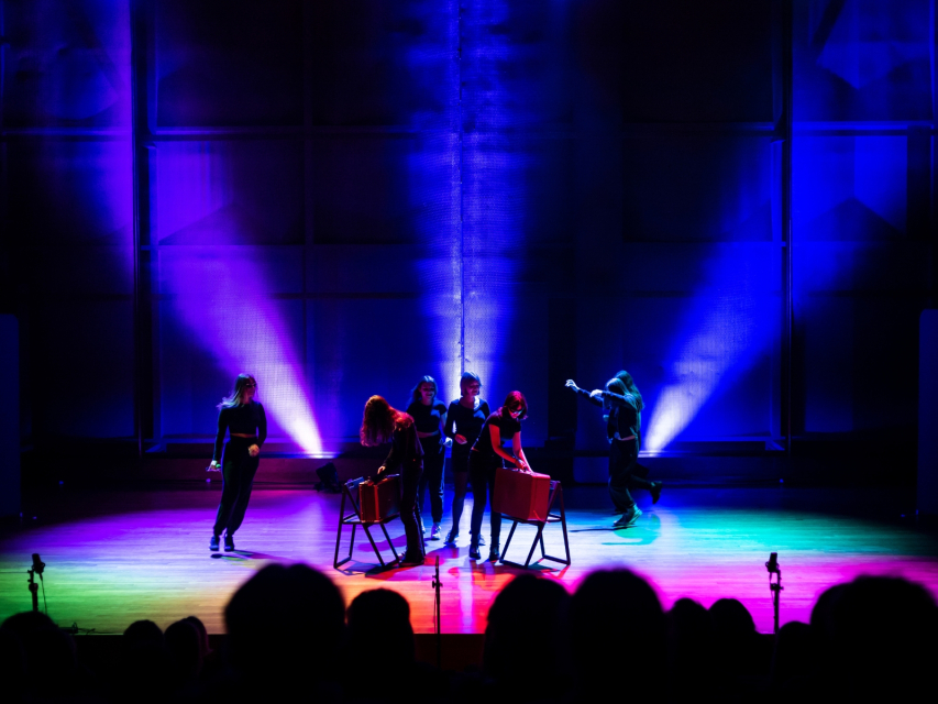 Aktorki i aktorzy Teatru Forum stoją na podświetlonej scenie podczas występu w Audytorium Muzeum POLIN.
