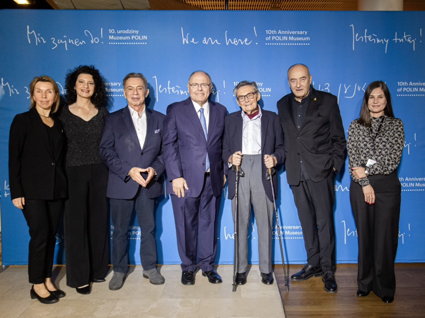 Przy ściance z okazji 10. urodzin Muzeum POLIN stoją od lewej: Jolanta Gumula, Piotr Wiślicki, Dani Dayan, Marian Turski, Zygmunt Stępiński i Łucja Koch.