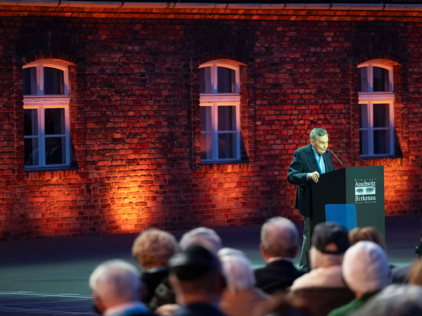 Marian Turski stoi przy mównicy podczas obchodów 80. rocznicy wyzwolenia obozu Auschwitz-Birkenau.