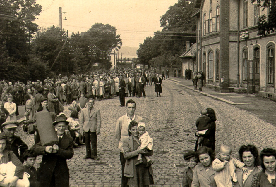 Żydowscy uchodźcy, zebrani przez działaczy Brichy w Polsce podczas podróży do Palestyny, stoją na brukowanej ulicy.