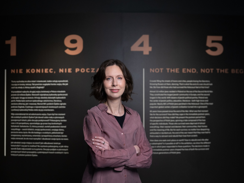 Zuzanna Schnepf-Kołacz na tle planszy z napisem "1945. Nie koniec, nie początek".