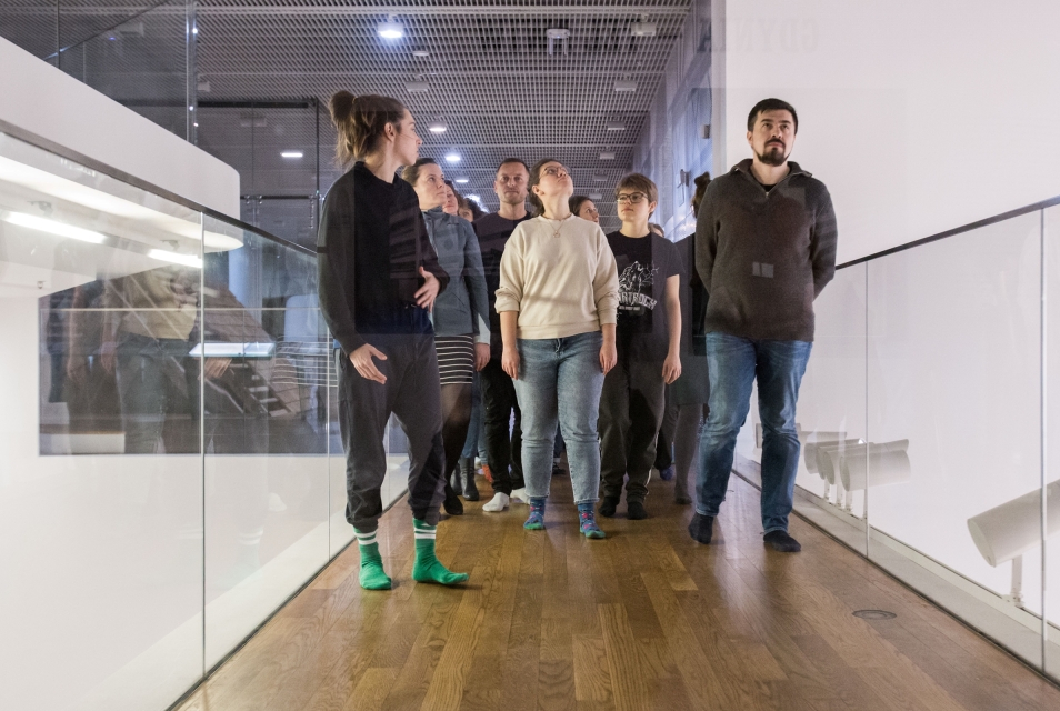 A group of people walks down the corridor through the POLIN Museum.