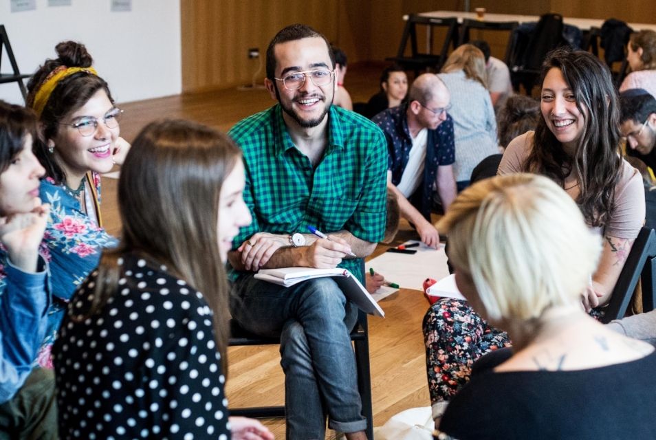 Participants in educational classes at the POLIN Museum work in groups. They smile.