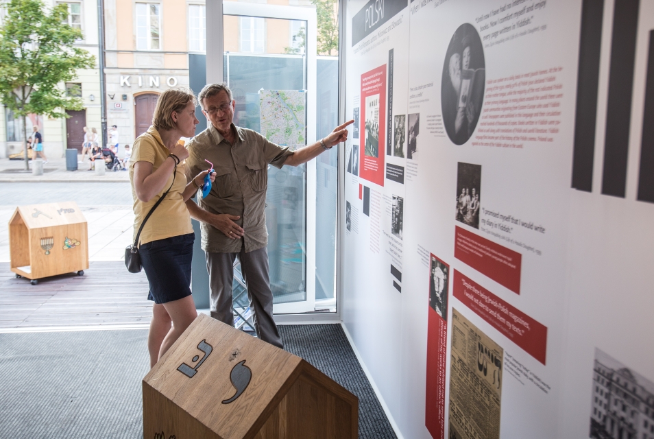 Mężczyzna i kobieta oglądają wystawę w pawilonie "Muzeum na kółkach" na Krakowskim Przedmieściu w Warszawie.
