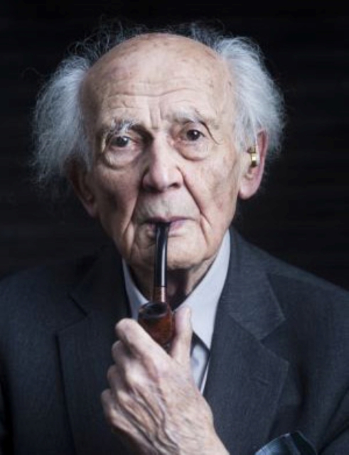 Zygmunt Bauman trzyma fajkę w ustach.