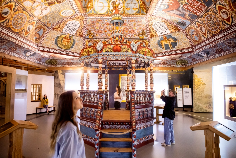 Kilkoro zwiedzających stoi obok rekonstrukcji synagogi z Gwoźdźca prezentowanej na wystawie stałej.