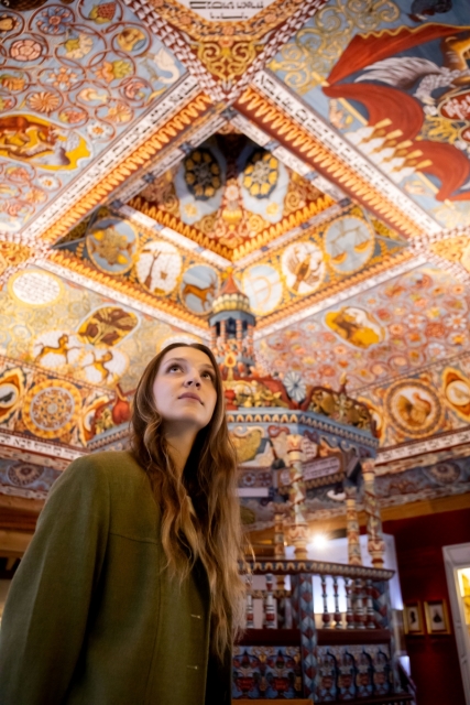 Kobieta stoi przy rekonstrukcji synagogi z Gwoźdźca na wystawie stałej.