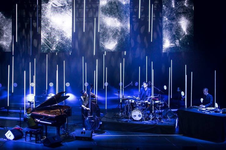Koncert. Na scenie zespół z instrumentami muzycznymi.