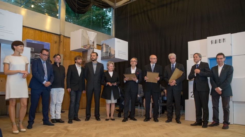 Grupa nagrodzonych osób stoi w rzędzie.