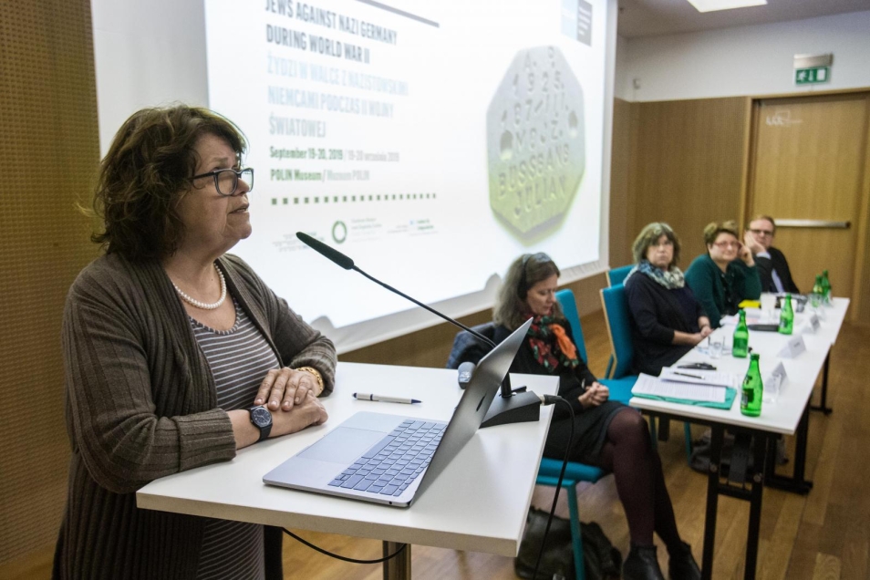Konferencja "Żydzi w walce z nazistowskimi Niemcami podczas II wojny światowej". Na zdjęciu, przy pulpicie mównicy w sali wykładowej stoi Anna Bikont, przy stole siedzą (od lewej): Andrea Löw, Barbara Engelking, Natalia Aleksiun, Krzysztof Persak