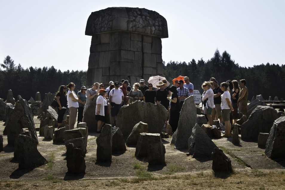 Grupa osób na cmentarzu przy pomnikach