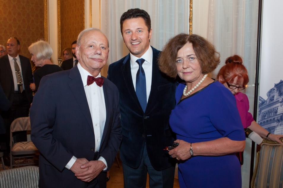 Zygmunt Rolat pozuje do zdjęcia z dwiema osobami.