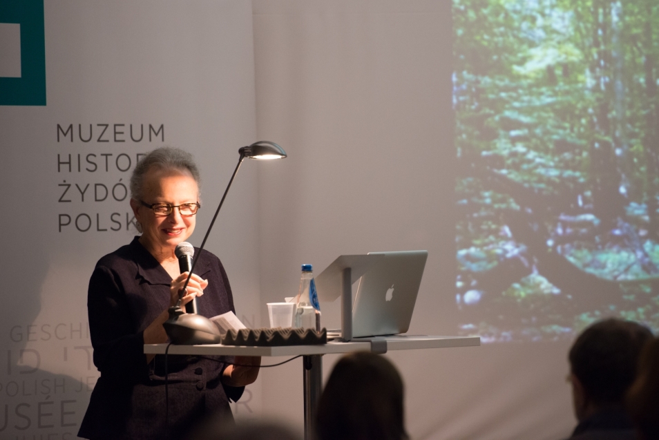 Barbara Kirshenblatt-Gimblett przy mikrofonie. W tle logo Muzeum POLIN.
