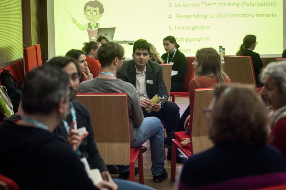 A group of teachers during workshops. People working in a small groups. Each of the group sits in a separate circle and discuss.