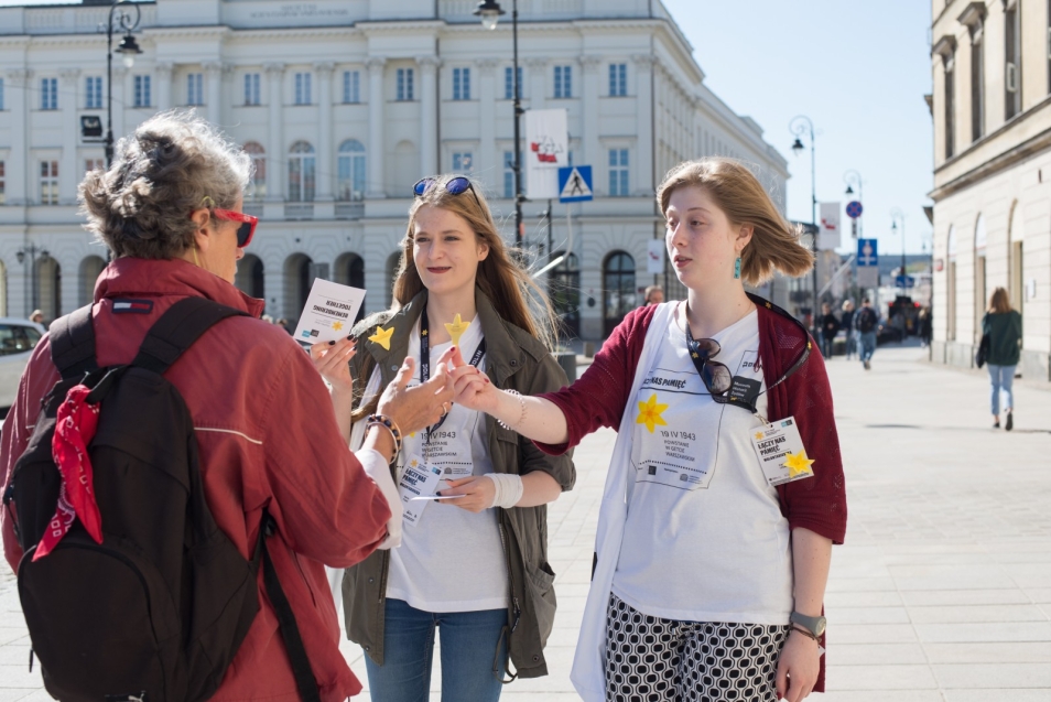 Wolontariusze akcji społeczno-edukacyjnej Żonkile 2018 rozdają papierowe żonkile przechodniom.