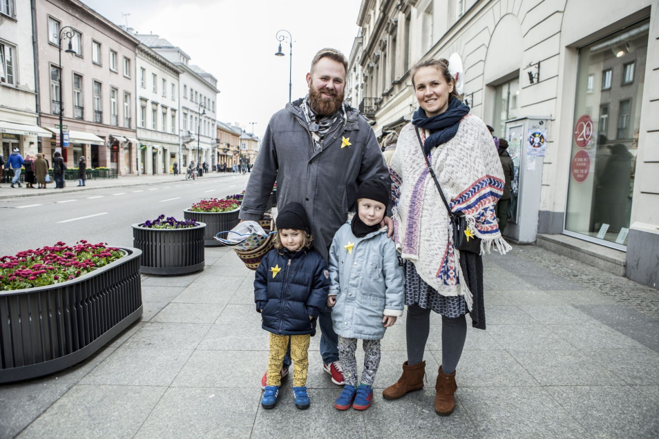 Rodzice z dwojgiem dzieci na Nowym Świecie w Warszawie - do ubrań mają przypięte papierowe żonkile.