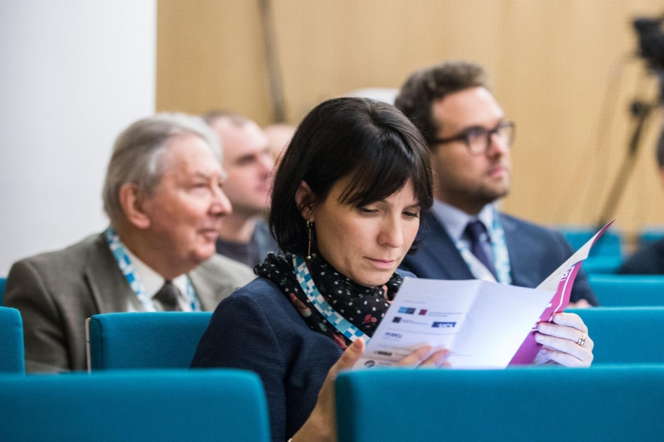Na zdjęciu: słuchacze konferencji. Na pierwszym planie widać kobietę, która czyta program konferencji
