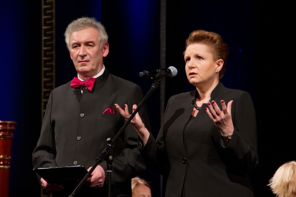 Gala w Teatrze Wielkim-Operze Narodowej. Aktor i aktorka na scenie, oboje stoją przy mikrofonie.