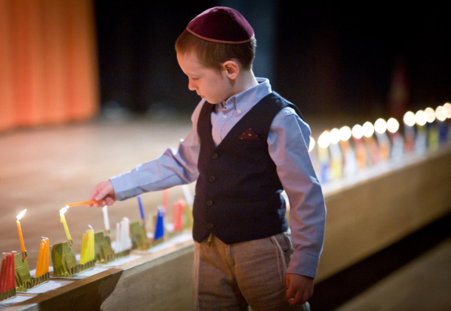 Mały chłopiec i palące się świeczki na Chanuka