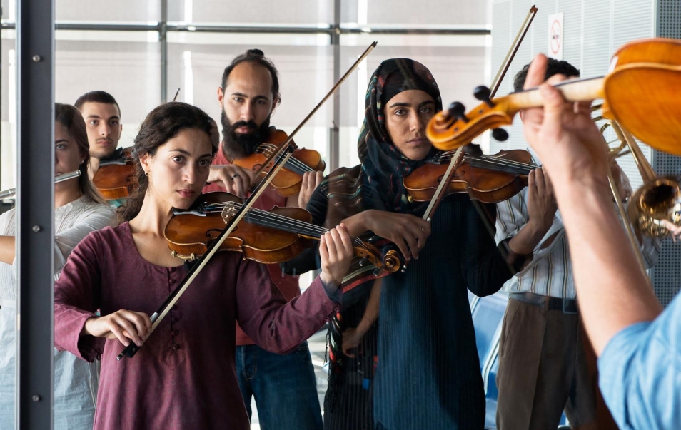 Crescendo #makemusicnotwar, reż. Dror Zahavi, prod. Alice Brauner, Niemcy 2019, 102 min, dramat, Na zdjęciu: grupa kobiet i mężczyzn gra na skrzypcach