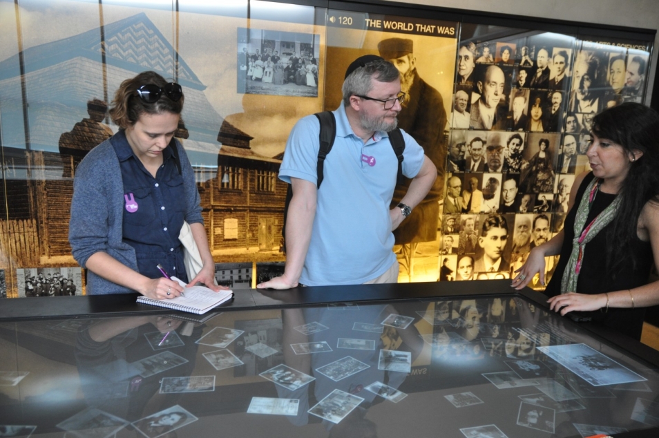 Dwoje zwiedzających z przewodniczką na wystawie w muzeum.