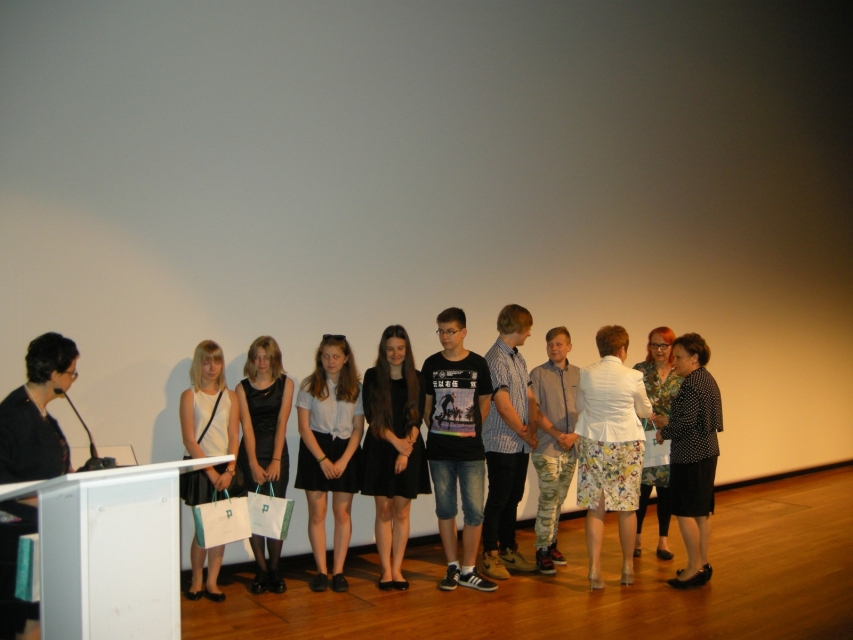 Grupa laureatów stoi na scenie.