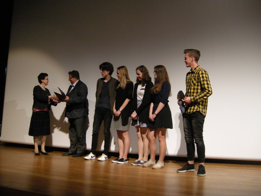 Grupa laureatów stoi na scenie.