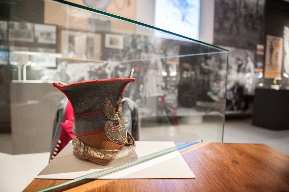 Eksponat - czapka z orzełkiem - w gablocie na wystawie w Muzeum POLIN.