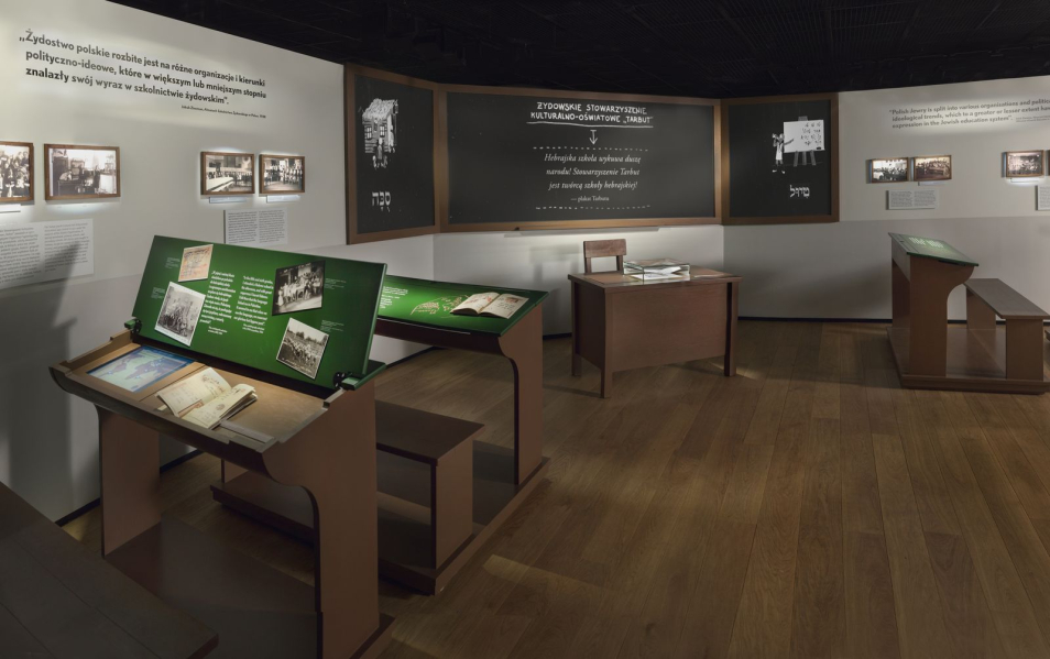 Galeria "Ulica" na wystawie stałej. Sala dotycząca szkolnictwa żydowskiego. Ławki szkolne z zeszytami i podręcznikami.