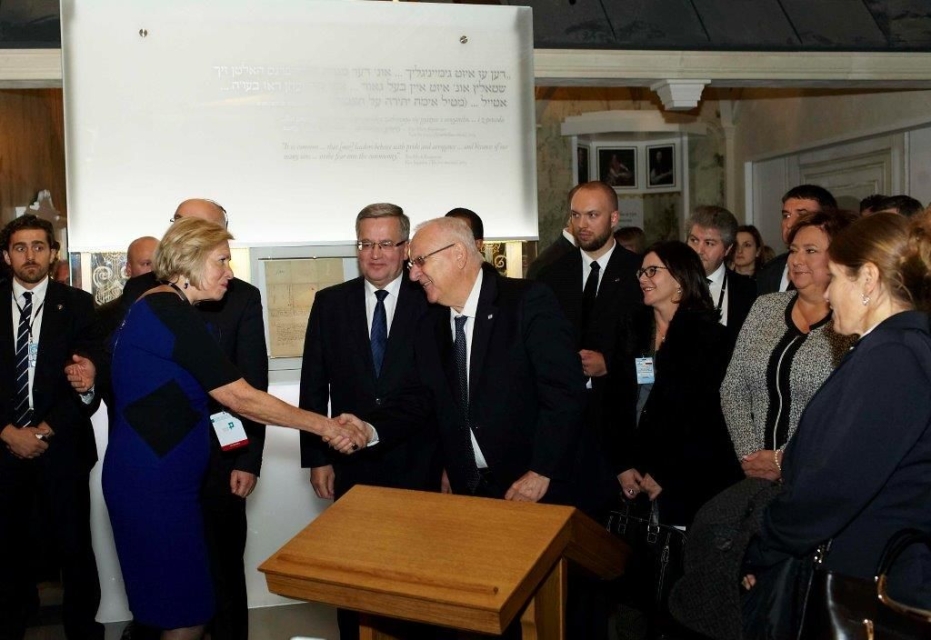 Bronisław Komorowski otoczony przez grupę ludzi.