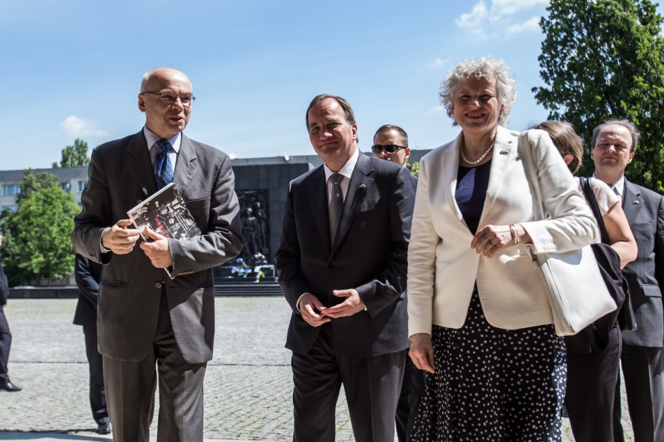 Grupa elegancko ubranych osób stoi na placu przed Muzeum POLIN.