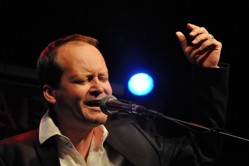 Jacek Bończyk śpiewa przy mikrofonie.