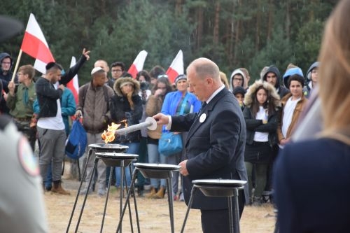 Jesteśmy razem - pamięci ofiar pomordowanych w Treblince. Mężczyzna w garniturze zapala świecę.