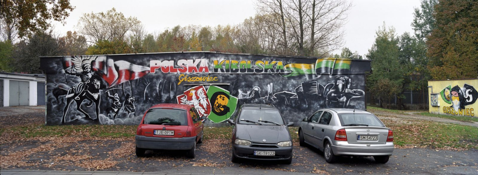 Trzy samochody na parkingu.