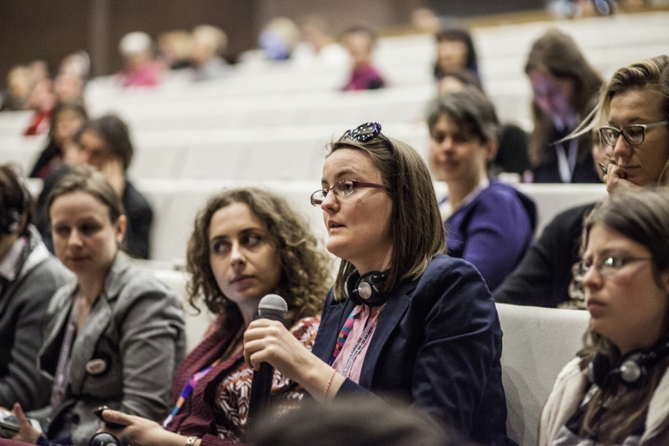 Kobieta z mikrofonem w auli Muzeum podczas konferencji