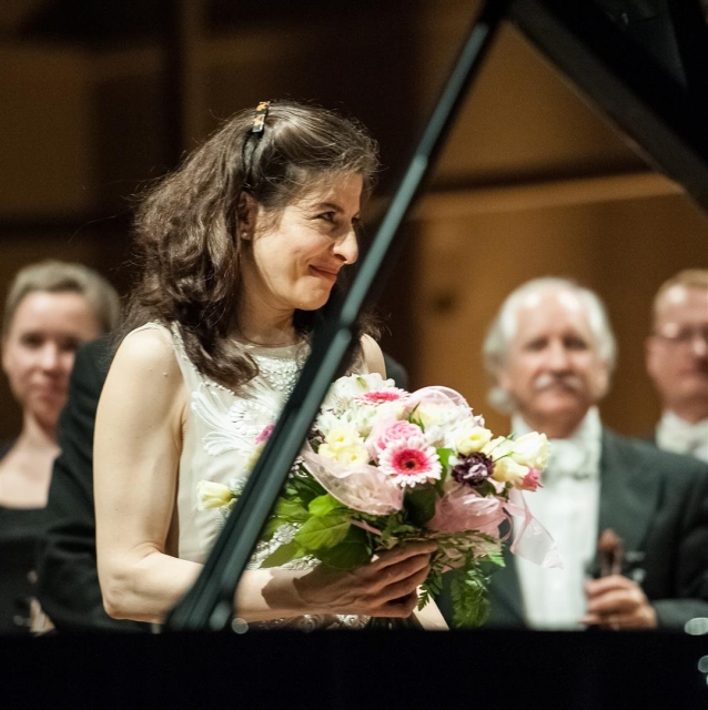 Po zakończonym koncercie pianistka trzyma w rękach kwiaty.