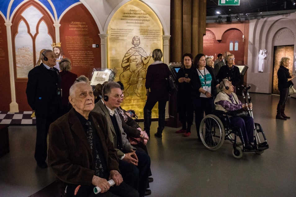 Grupa starszych zwiedzających na wystawie stałej w Muzeum POLIN