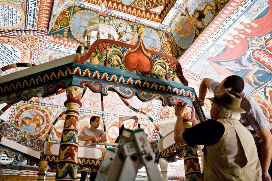 Dwaj mężczyźni mocują fragment bimy, elementu zrekonstruowanej synagogi w Muzeum POLIN.