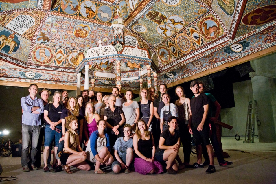 Grupa ludzi przed zrekonstruowaną synagogą w Muzeum POLIN.