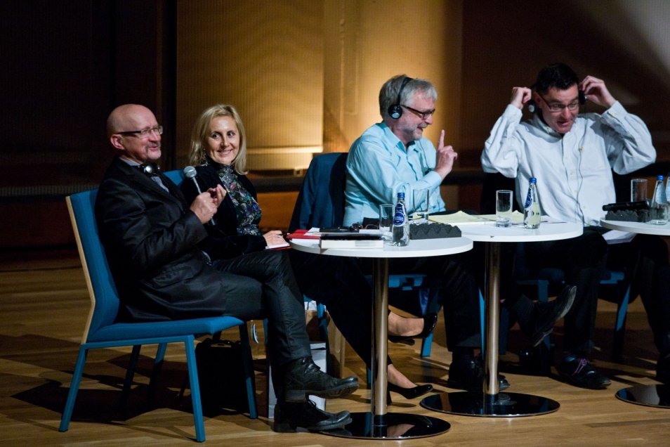 Czworo panelistów siedzi przy stoliku podczas debaty.