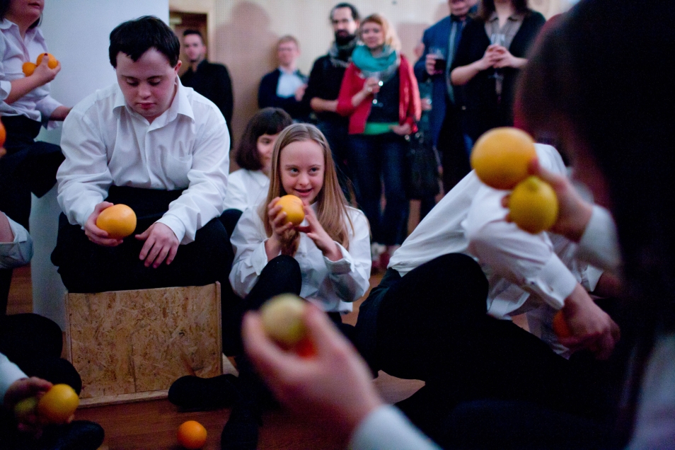 Występ Teatru 21. Aktorzy trzymają pomarańcze.
