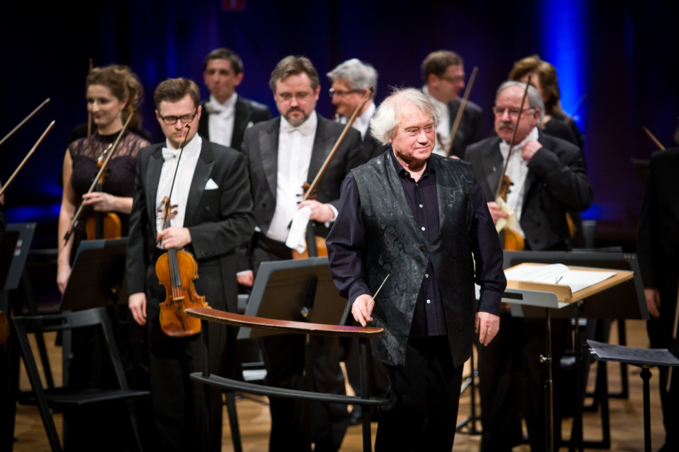 Dyrygent i muzycy orkiestry Sinfonia Varsovia na scenie.