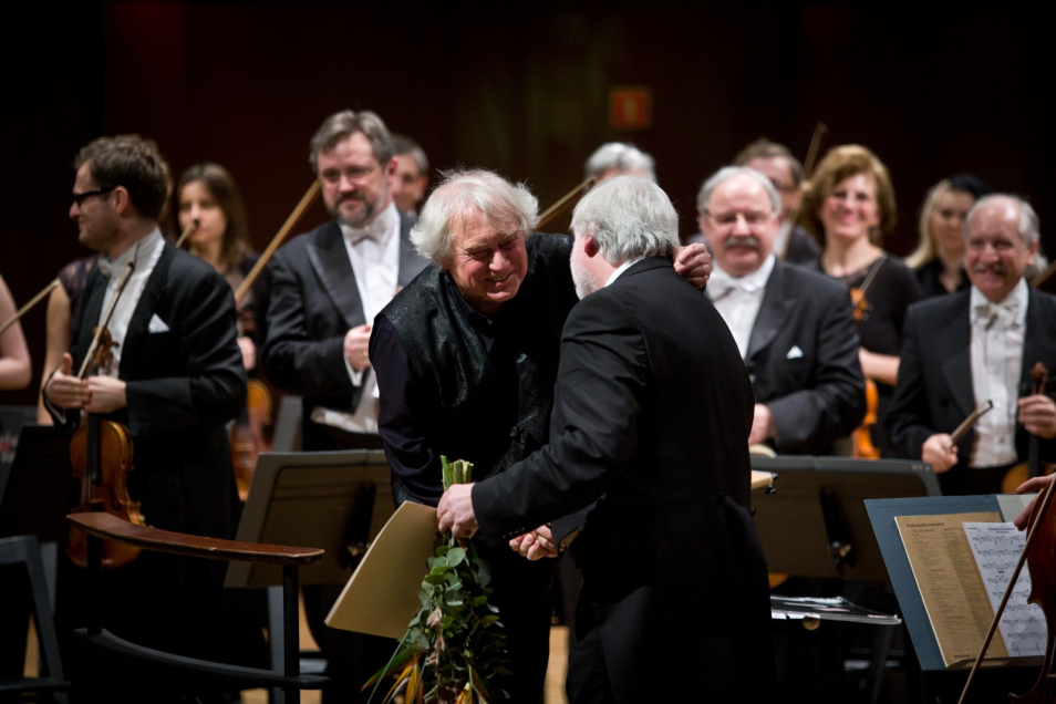 Dyrygent i muzycy orkiestry Sinfonia Varsovia na scenie.