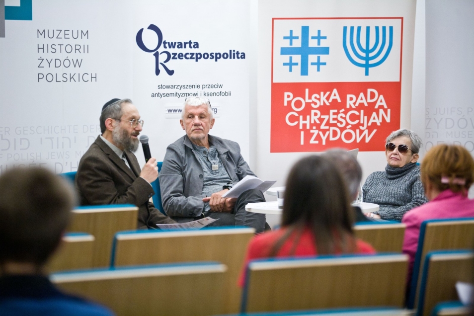 Prelegenci i uczestnicy dyskusji "Uwierzyć w muzeum" siedzą w sali konferencyjnej.