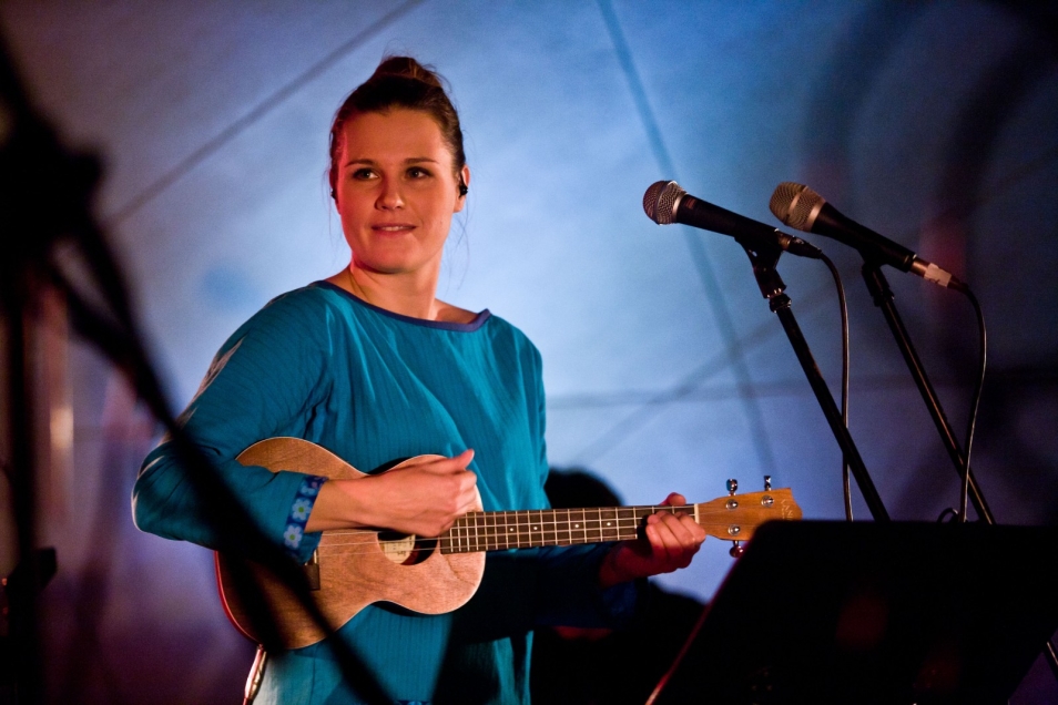 Kobieta gra na gitarze podczas balu chanukowego.
