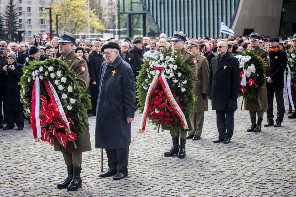 Władysław Bartoszewski składa kwiaty w asyście żołnierzy przed pomnikiem Bohaterów Getta.