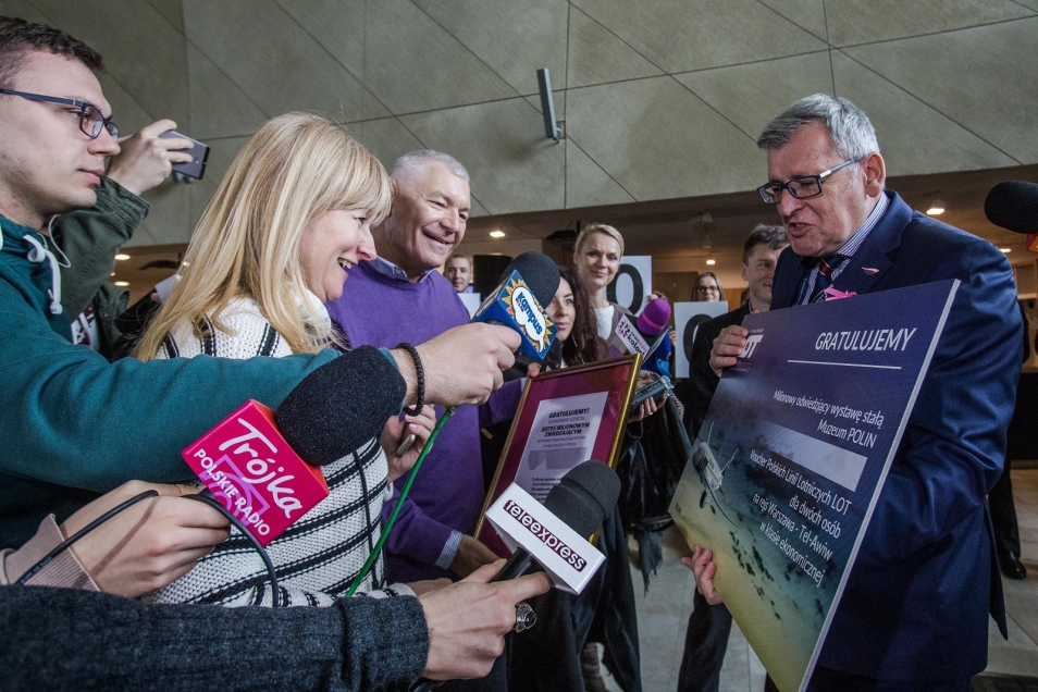 Milionowy odwiedzający w Muzeum POLIN. Wokół niego zgromadzeni dziennikarze.