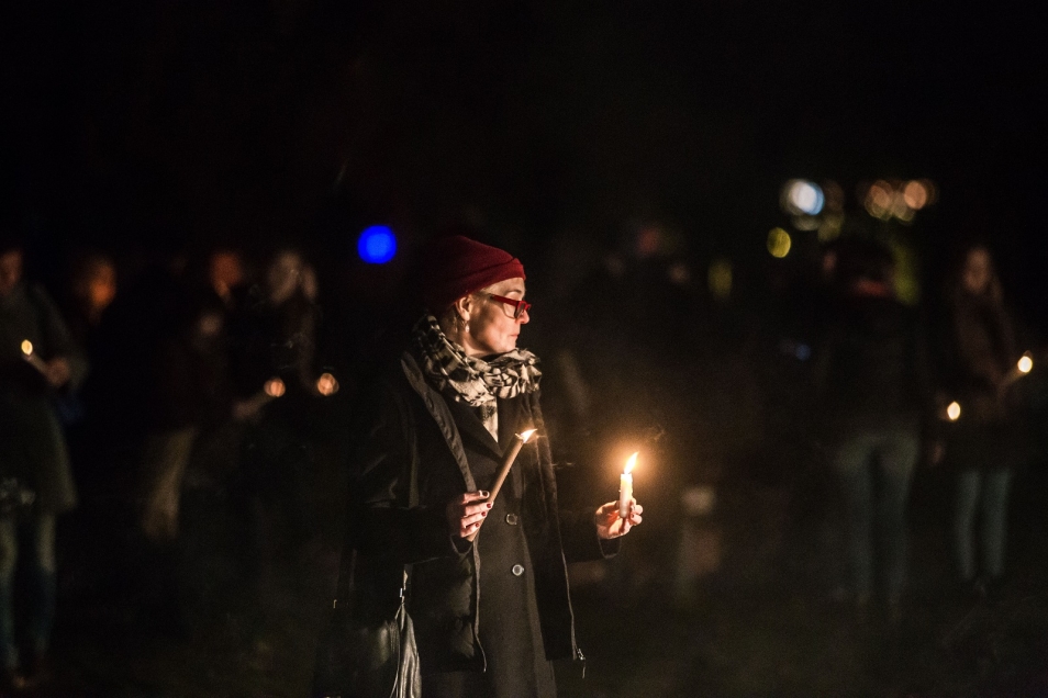 Kobieta trzyma dwie świece. Obie są zapalone.