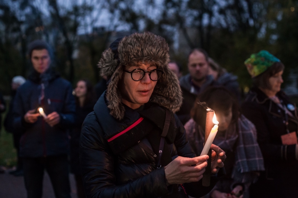 Kobieta trzyma zapaloną świeczkę.