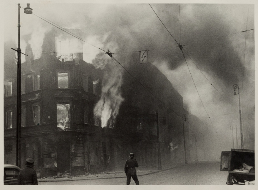 Płonący budynek w getcie warszawskim w kwietniu 1943 r. Czarno-biała fotografia.